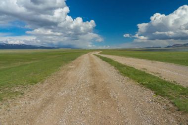 Toprak yol mavi gökyüzüne gidiyor.