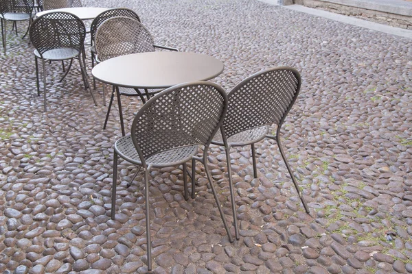 Cafe masa ve sandalyeler üzerinde kaldırım taşı döşeli Street, Bologna