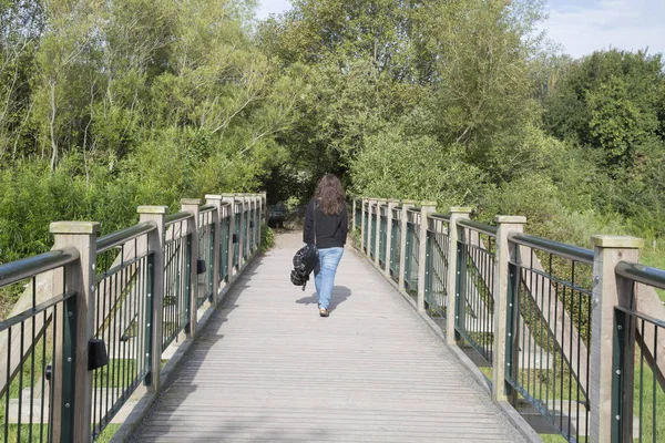 Mujer caminando sobre puente de madera — Foto de Stock