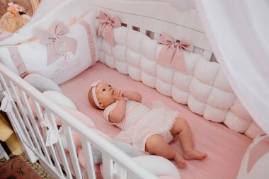 Bebek yatakta bandajlı.