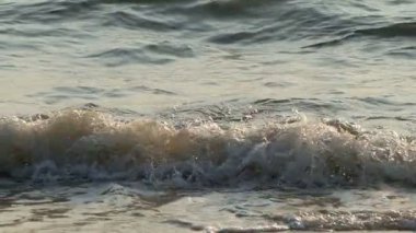 Gün batımında sahile vuran küçük dalgaların çekimleri yavaş çekimde
