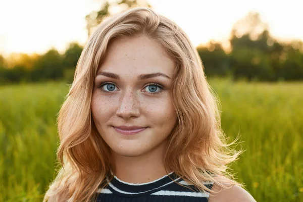 A close-up of a pretty young girl with charming smile standing on green background — Stock Photo, Image