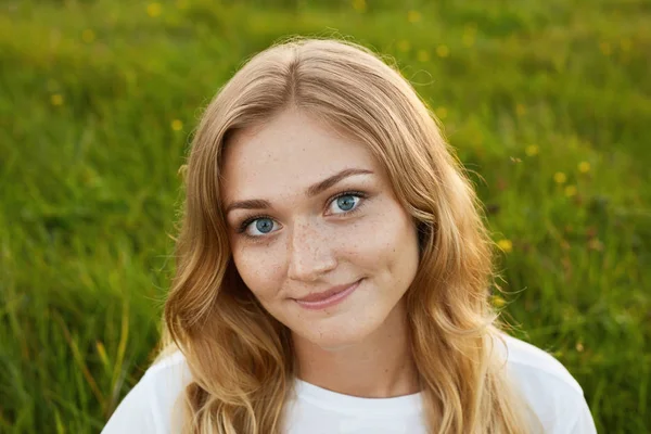 Портрет девушки с красивой улыбкой с ямочкой на лице в белой футболке на зеленом фоне — стоковое фото
