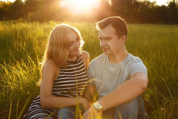 Bon couple en plein air. Couple souriant relaxant sur l'herbe verte. Fille et garçon sur fond vert nature. De bonnes relations. Concept romantique. L'heure d'été. Détente en plein air. Couple amoureux — Photo