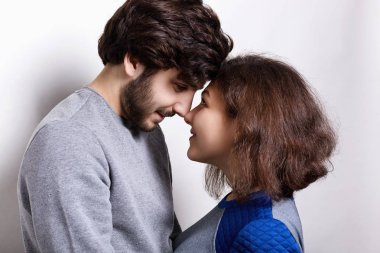 İnsanlar, duygular, ilişkiler kavramı. Mutlu güzel çift portresi: genç sakallı adam ve çekici kız birbirlerinin burunlarını birbirine bakarak büyük bir sevgi ve zevk ile dokunmak