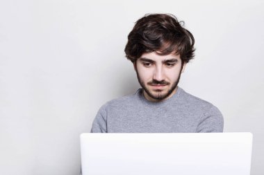 İnsanlar, teknoloji ve iletişim kavramı. Mutlu şık açık laptop önünde oturan ve ücretsiz yüksek hızlı internet bağlantısı beyaz duvar izole kullanarak çalışma hipster sakallı