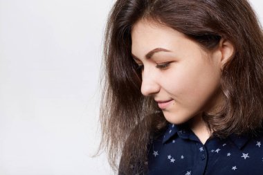 Güzel esmer kara kaşları, uzun kirpik ve saf deri yana doğru bir close-up düşünceli bir ifadeyle bakıyor karanlık gömlek giymiş. İnsanlar ve moda kavramı.