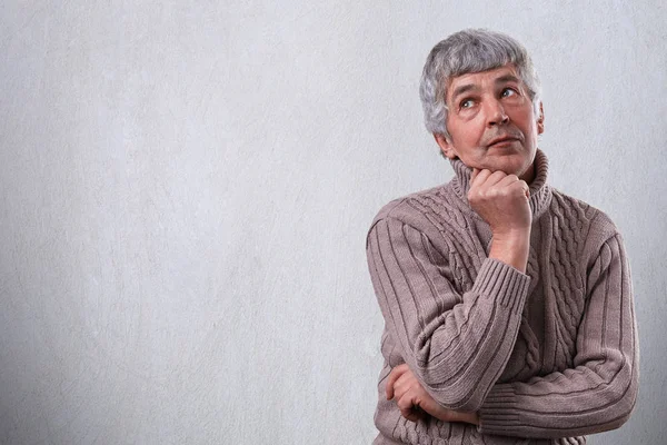 Un ritratto di uomo anziano sognante premuroso in piedi su sfondo bianco con spazio copia per il tuo annuncio. Uomo maturo nel profondo del pensiero cercando di ricordare qualcosa della sua vita — Foto Stock