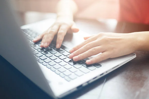 Les gens et la technologie moderne concept. Gros plan des mains féminines tapant sur le clavier de son ordinateur portable. Jeune femme d'affaires travaillant sur ordinateur portable au bureau. Messages de dactylographie féminine freelance — Photo