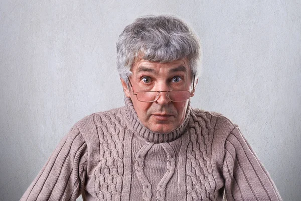 A horizontal medium close-up of an elderly man with gray hair nice eyes having wrinkles on the face wearing eyeglasses posing against white background looking with wide opened eyes. Wisdom concept. — Stock Photo, Image