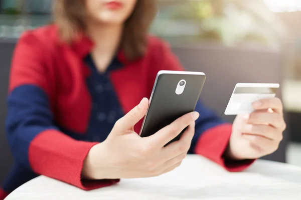 Mujer sosteniendo teléfono móvil y tarjeta —  Fotos de Stock