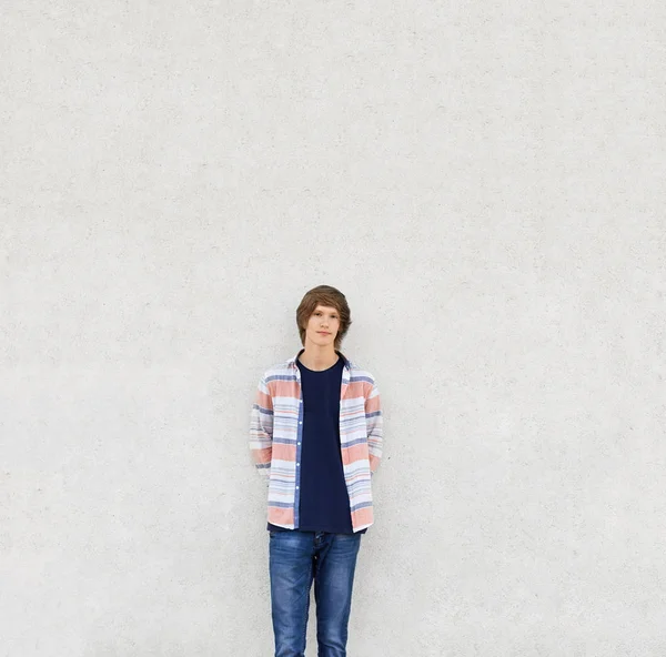 Jovem com corte de cabelo na moda vestindo camisa e jeans de pé n — Fotografia de Stock