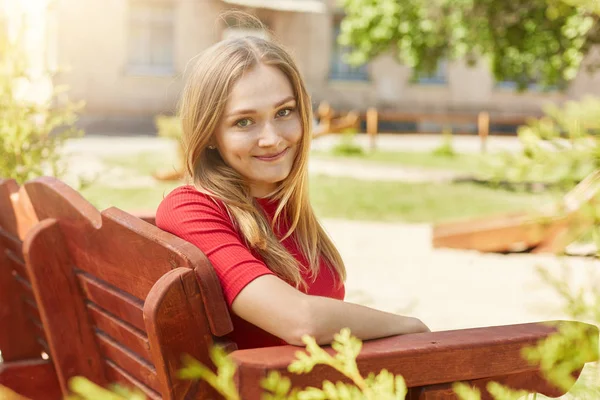 Красивая девушка сидит на скамейке — стоковое фото