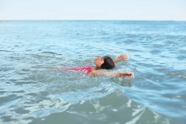 Sırtında, derin Denizde yüzme yalan mayo rahat küçük kız manzara, gökyüzüne, gevşeme, dinlenme sırasında onun yaz tatillerini duygu seyir zevk. İnsanlar, geri kalan kavramı