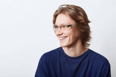 Sınav, onun başarı sevindirici hoş gülümseyen erkek öğrenci iyi bir ruh hali, sahip akıllı ifade ile. Rahat t-shirt bir kenara neşeli ifade ile seyir içinde erkek girişimci gülümsemek