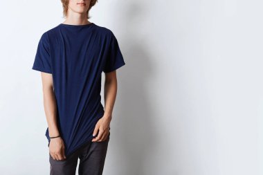 Atış yakışıklı hipster adam reklam veya metin için boş alan ile t-shirt giyen kırpılmış. Genç erkek beyaz arka plan kopya alanı ile poz. Giyim ve reklam kavramı