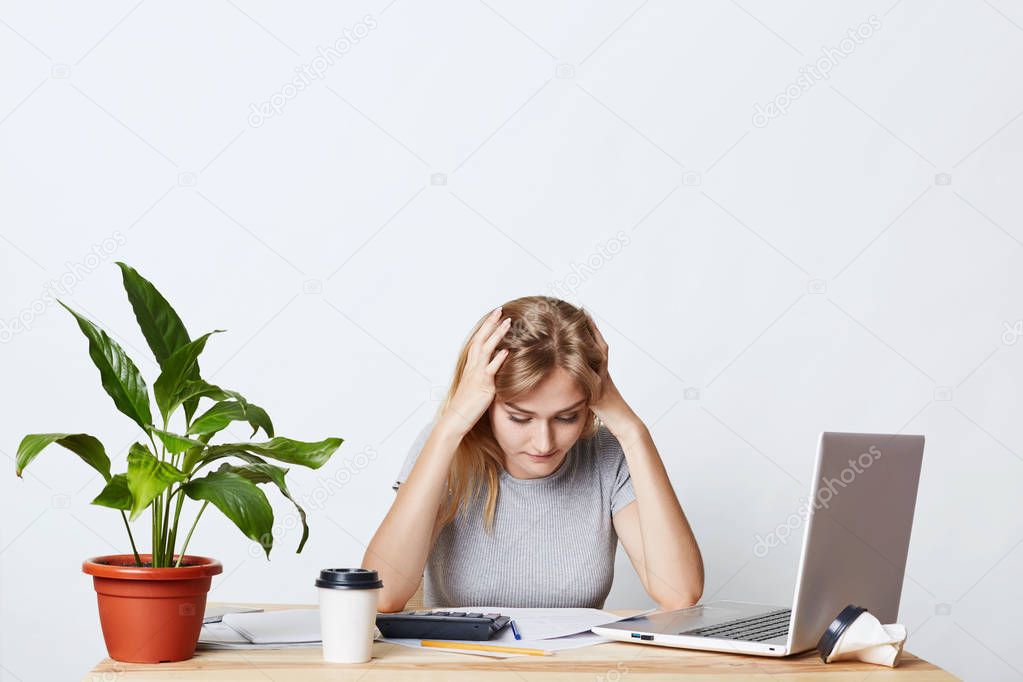Concentrated female being involved in business process, reading attentively documents, trying to understand what to do, using modern technologies for her work. People, career and business concept