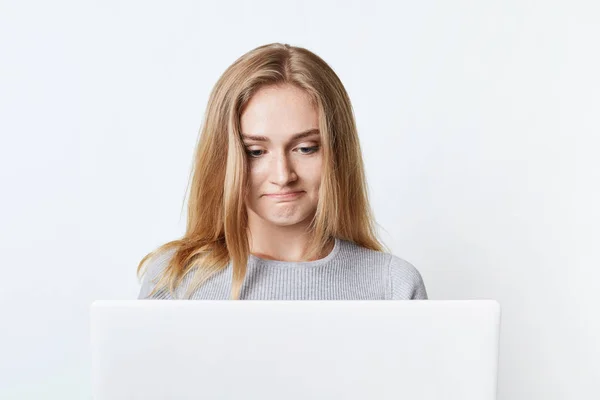 Vrij vrouwelijke blogger zit voor geopende laptop, schrijft nieuwe post, maakt het gebruik van high-speed internetverbinding thuis. Mooie vrouw surfes sociale netwerken gebruikt laptopcomputer voor communicatie — Stockfoto