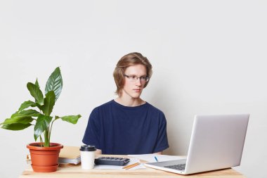 Ciddi erkek Yöneticisi mali evde yönetir, laptop ve hesap makinesi kullanır, grafik ciddi bir ifadeyle görünüyor, sabah kahve içiyor. Akıllı Amerikalı işadamı yeni strateji geliştirir