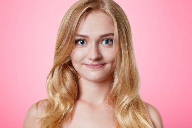 Pure ile kadın arıyor hoş sıcak çekici gözler ve çekici gülümseme, sağlıklı deri uzun hafif saçlı, içine doğrudan kamera pembe arka plan üzerinde izole, görünüyor. Güzellik ve gençlik kavramı