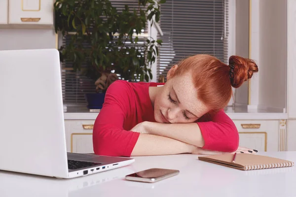 Tired fatigue ginger female student works all night at course paper, falls asleep directly at working place, surrounded with modern technologies. People, studying, tiredness, working concept. — Stock Photo, Image
