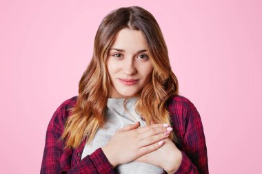 Beden dili kavramı. Güzel dost görünümlü genç erkek casual t shirt, elleri göğsünde duruyor, onun Şükran ve minnet ifade, teşekkürler, pembe bir arka plan üzerinde izole diyor.