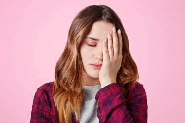 Yorgunluk genç kadın yakışıklı uykulu ifadesi olan, el, overworked, hazırlanmış ders veya diploma kağıt üzerinde pembe arka plan izole bütün gece olmak gözlerle kapsar. Yorgunluk ve iş kavramı