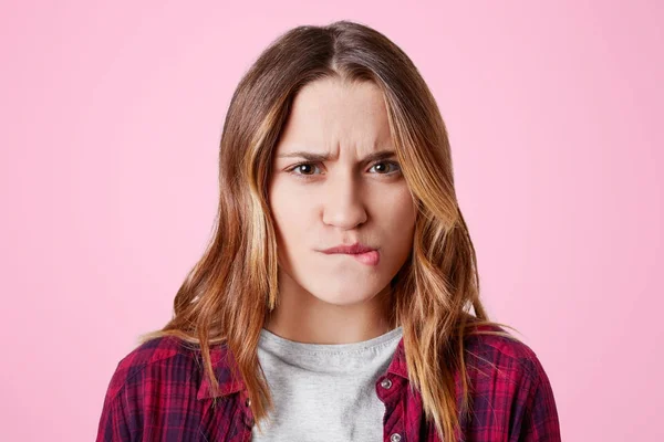 Primer plano retrato de las curvas femeninas insatisfechas labios y frunce el ceño, molesto como pelea con alguien, expresa emociones negativas, aislado sobre fondo rosa. Estresado descontento mujer interior — Foto de Stock