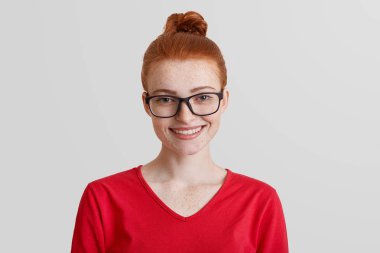 Kırmızı saçlı genç gülümseyen kadın stüdyo çekim giyer kare gözlükler ve kırmızı kazaklı, iş, gayretli çalışma ve achievent büyük bir başarı için alır Ödülü promosyonu sonra keyfi yerinde olmak