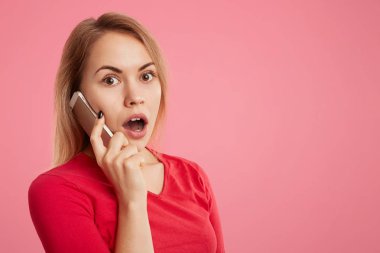 Şok şaşkın genç erkek telefonla, reklam veya promosyon metni kopyalama yeri olan pembe bir arka plan üzerinde izole beklenmedik haberler duymak için sürpriz telefon görüşme vardır.