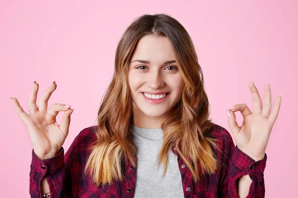 Alegre modelo femenino de aspecto agradable con cabello largo y apariencia atractiva se encuentra en gesto mudra, demuestra tranquilidad, relajación y ambiente tranquilo. Mujer trata de relajarse en el interior — Foto de Stock