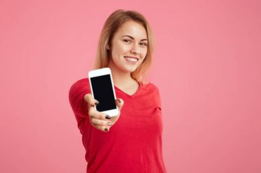 Parlayan ile güzel erkek gülümseme ile boş kopya perde, reklam, fonksiyonları ile memnun için akıllı telefon gösterir pembe arka plan üzerinde izole. Kavramı reklam insanlar, teknoloji,