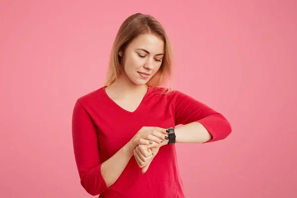 Joven hembra tiene mirada atractiva, comprueba el tiempo en su reloj, viene en la reunión anterior, aburrido de esperar. Empresaria se apresura en la oficina, mira el reloj de pulsera, se da cuenta de que llega tarde al trabajo — Foto de Stock