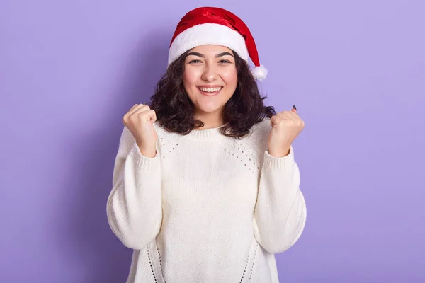 Mooi vrouwelijk model met rode kerstman en witte trui — Stockfoto