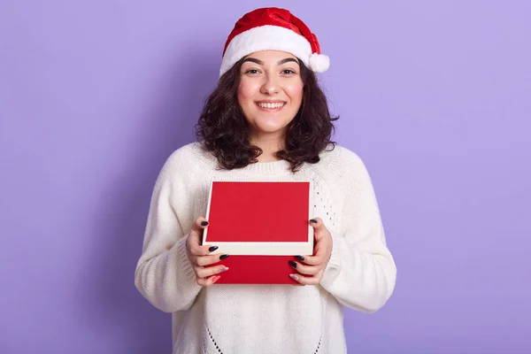 Портрет веселой нежной брюнетки, держащей коробку с подарком в — стоковое фото