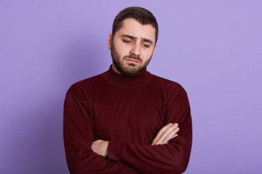 Hayal kırıklığına uğramış esmer, kollarını kavuşturmuş, aşağı bakıyor, kaşlarını çatmış, kötü ruh halinde, kırmızı kazak giymiş, şanssız bir gün geçiriyor. İnsanlar ve duygular.