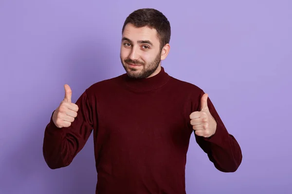 Close up portrait of nice attractive energetic young man having positive facial expression, being peaceful, raising both hands, showing sign super, making gesture, looking directly at camera. — Stock Photo, Image