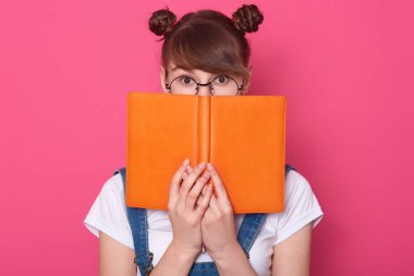 Kazanan, komik saçlı çörekleri olan, turuncu kitabın, günlüğün ya da planlayıcının arkasına saklanan, gözlüklü, beyaz tişörtlü, boynuna kırmızı bandana takan ve kot pantolon giyen genç bir kız..