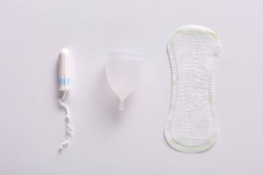 Kadınların mahrem hijyen ürünlerinin resmi. Beyaz arka planda izole edilmiş hijyenik pedler, regl bardağı ve tampon görüntüsü. Kızların hijyeninin farklı yöntemleri. Ginekoloji ve samimi kavram.