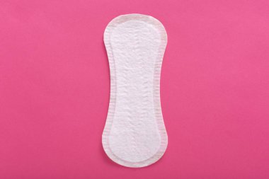 Kullanılmaya hazır, tek kullanımlık, fotoğrafın ortasında bulunan, regl sırasında kadınsı hijyen içeren temiz, kullanılmamış hijyenik pedin yatay resmi. Düz yatıyordu. Üst görünüm.