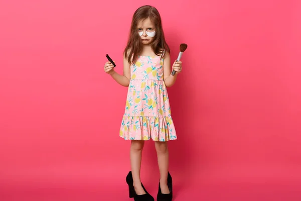 Portret Dość Zdenerwowanego Emocjonalnie Dziecka Pozującego Różowym Tle Trzymającego Pomade — Zdjęcie stockowe