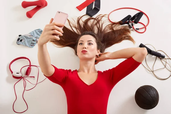 Woman Wearing Red Shirt Lying White Surfaceholds Surrounded Different Sport — Stock Photo, Image