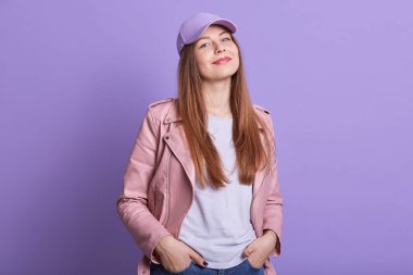 Uzun sarı saçlı, el ele tutuşan, doğrudan kameraya bakan, huzurlu bir yüz ifadesi takınan, gündelik giysiler giyen güzel ve çekici bir kadının yatay fotoğrafı. Gençlik kavramı.