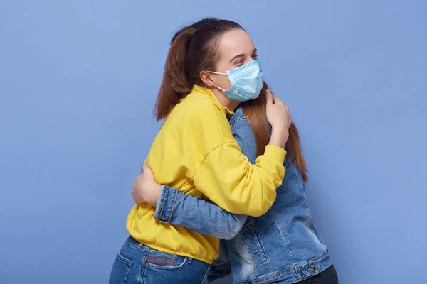 Imagen Horizontal Dos Mujeres Jóvenes Infectadas Usando Máscaras Protección Abrazándose — Foto de Stock