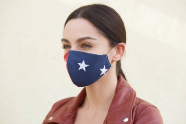 Dalgın kadın portresi kahverengi deri ceket ve yıldızlı ev yapımı koruyucu maske, Corona virüsünü hızla yaymaktan kaçınan kadın, sağlığına dikkat ediyor. Covid 19.