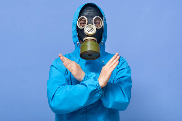 Indoor shot of chemical scientist showing stop gesture with crossing hands, ecologist works in dangerous area with high level of radiation, forbids coming to this territory. Safe planet concept.