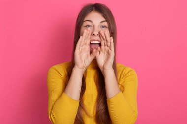 Gürültülü, sevimli, güzel bir kadının portresi. Ağzını geniş bir şekilde açıyor. Elleri ağıza alıyor, bağırıyor, gürültü yapıyor..