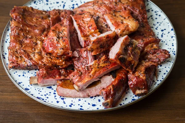 Geräucherte Schweinerippchen auf einem dekorativen Teller. Essen und Kochen. — Stockfoto