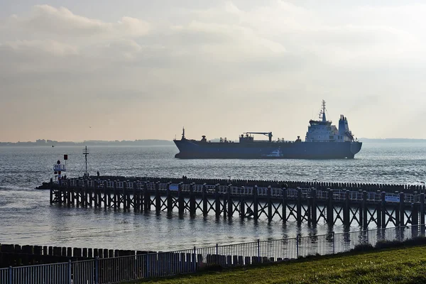 Frachtschiff fährt bei Gegenlicht in Hafen von Vlissingem ein — Stockfoto