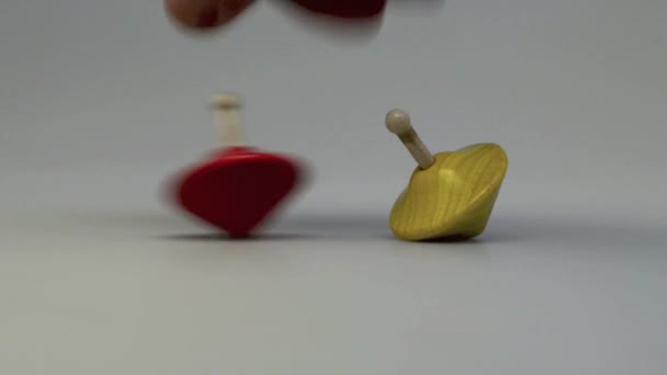 Two wooden and colorful spinning tops. — Stock Video